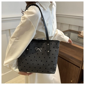 Detailansicht der grauen Polka-Dot-Einkaufstasche mit silberner Schleife und Riemen