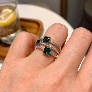 Three-piece ring set with emerald cut green gemstones and pavé stones on silver band