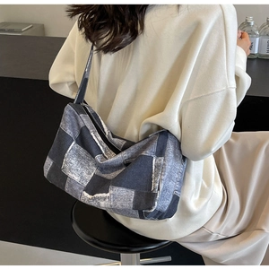 Détail du sac bandoulière en denim patchwork avec motif à carreaux rétro porté à l'épaule