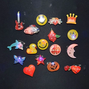 Assorted LED light-up pins with cartoon shapes like guitars and hearts for night parties