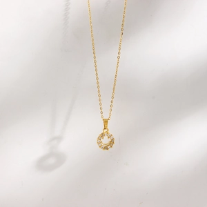 Close-up of 18K gold plated necklace with hollow smiley face pendant and clear zircons