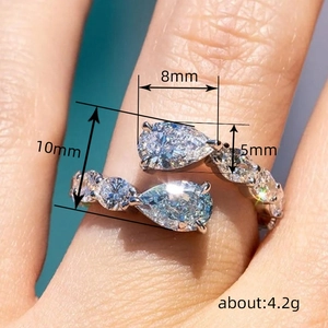 Fashionable teardrop open ring with blue stones and pave accents on a model's finger