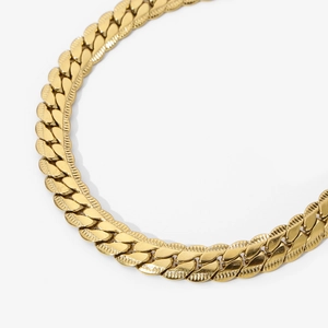 Close-up of golden embossed Cuban link chain showing glossy metallic texture and details