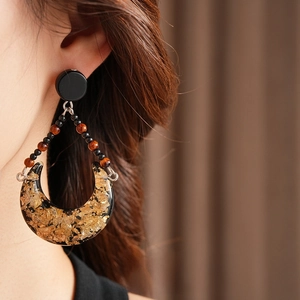 Vintage crescent resin earrings with gold leaf foil on model with soft lighting