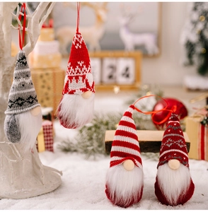 Detailed view of four Christmas gnome ornaments with knitted hats in a snowy festive setting