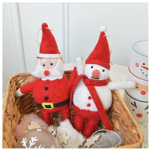 Close-up of wool felt Santa and snowman ornaments in a rustic woven basket for Christmas