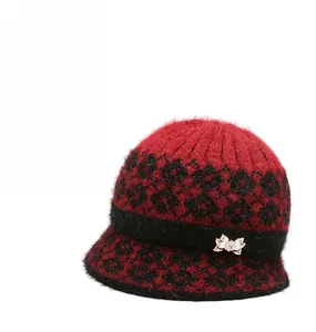 Detail of winter knit cloche hat with leopard pattern and metal bow accent