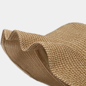 Close-up of the intricate hand-woven natural straw pattern on a wide brim sun hat
