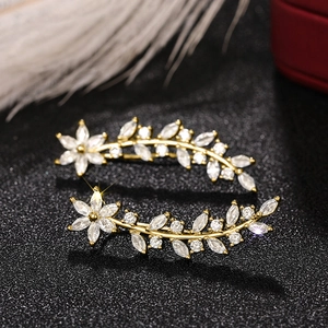 Macro detail of gold flower earrings with white crystals and sparkling marquise gems
