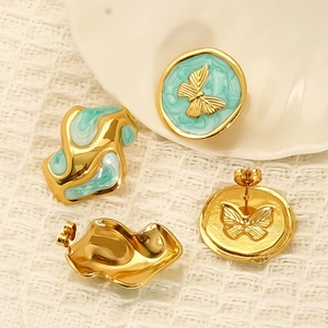 Irregular butterfly earrings in vintage gold and teal enamel on textured fabric