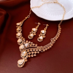 Detail of French vintage gold necklace and earring set on dark red silk background