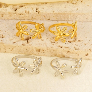 Detail view of gold and silver double floral adjustable open rings on stone texture