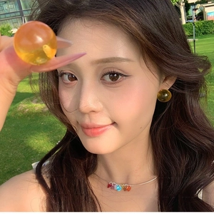 Colorful resin round studs and multi-color heart pendant necklace worn on summer grass