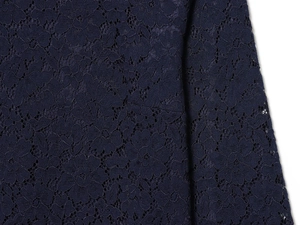 Macro shot of dark blue floral lace fabric with intricate hollowed-out texture details