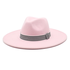 Detail of pink wide brim fedora hat featuring a stylish black and white striped ribbon band