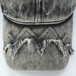 Macro shot of washed denim baseball cap featuring distressed frayed edges and Z-stitch detailing