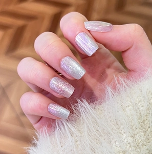 Macro shot of shimmering aurora pink and lavender press-on nails with glitter finish