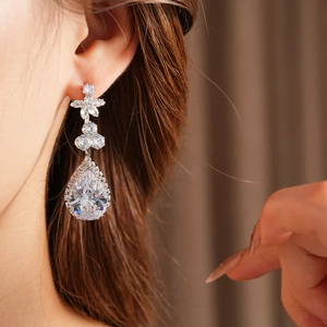 Close-up of elegant pear-shaped zircon drop earrings featuring a sparkling floral cluster