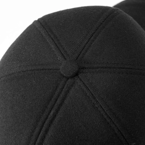 Detailed macro view of black cotton twill baseball cap crown with six-panel stitching