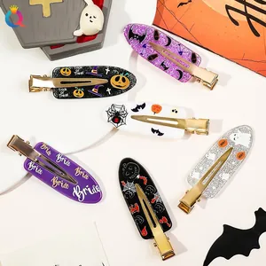 Detailed flat lay of Halloween hair clips with pumpkin, bat, and ghost motifs on acrylic