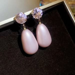 Detailed shot of pink teardrop pearl earrings with sparkling crystals in a jewelry box