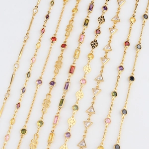 Close-up of gold-plated necklaces featuring multi-colored cubic zirconia gemstones