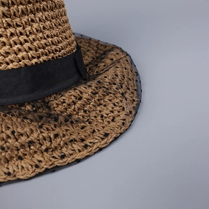 Close-up of woven straw sun hat texture featuring elegant black polka dot lace mesh detail