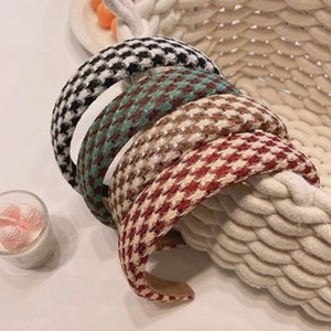 Detail of four plaid patterned fabric headbands in assorted colors displayed in a basket