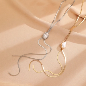 Flache Schlangenkette in Gold und Silber mit Barockperlen auf Seidenhintergrund