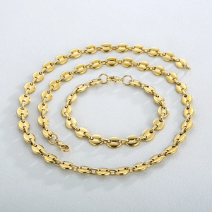 Detail shot of golden coffee bean link necklace and bracelet set on white background