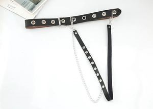 Detail of black PU leather punk belt with metal grommets and detachable leg chain