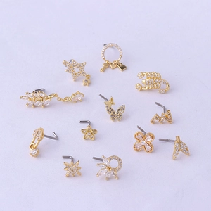 Set of 12 gold titanium L-shaped nose studs with zircon stars, moons, and leaves charms
