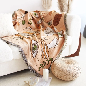 Detail of bohemian woven blanket featuring mushroom patterns and colorful fringe tassels