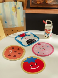 Lot de quatre dessous de verre motifs dessin animé fantôme et cookie sur table blanche