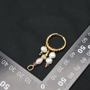 Golden baroque earrings with white pearls and colored beads shown next to a measuring ruler