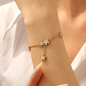 Gold-plated stainless steel chain bracelet with white clover shell flower charms on wrist