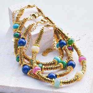 Close-up of bohemian colorful tourmaline beads and golden spacers on a steel bracelet