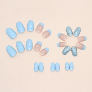 Aurora blue round oval press-on nails with clear glitter and French tips on light background