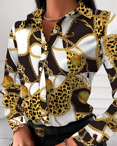 Details einer eleganten Langarmbluse mit Leopardenmuster, Kette und goldenen Knöpfen
