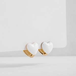 Close-up of white enamel heart earrings with gold clasp finish on a clean white background