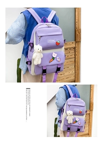Detailed view of purple nylon backpack featuring cute cartoon patches and plush bear charm