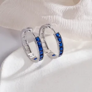 Elegant silver hoop earrings with rectangular blue emerald-cut stones in a row