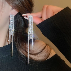 Boucles d'oreilles élégantes avec de longs pompons en strass étincelants.