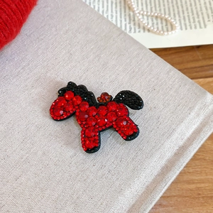 Detail of red rhinestone horse hair clip on elegant grey linen with pearl accents