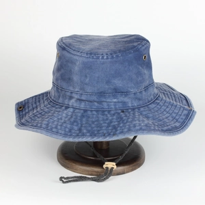 Macro shot of blue washed canvas fishing hat with metal eyelets and adjustable chin strap