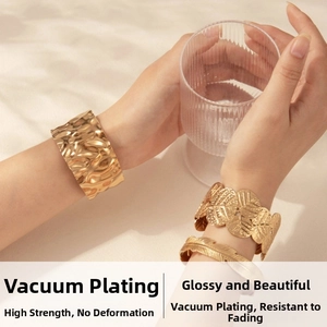 Detailed view of three gold-plated titanium steel bracelets with leaf and wave patterns