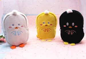 Detailed view of three cute plush duck cosmetic pouches in white, yellow, and black colors
