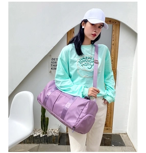 Outdoor shot of a woman carrying a purple cylindrical duffel bag for gym and travel use