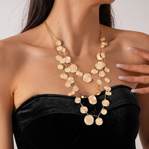 Detail of triple-layer gold layered necklace with hammered textured round metal sequins