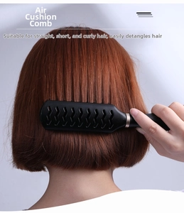 Detail of professional black vented paddle brush styling short reddish brown hair